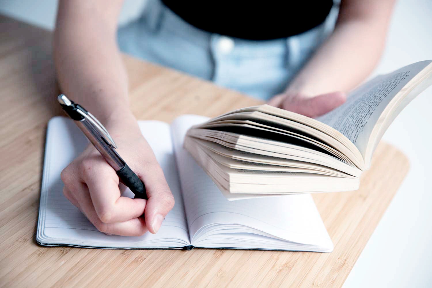 Photo de Camille écrivant des notes de lecture dans un carnet