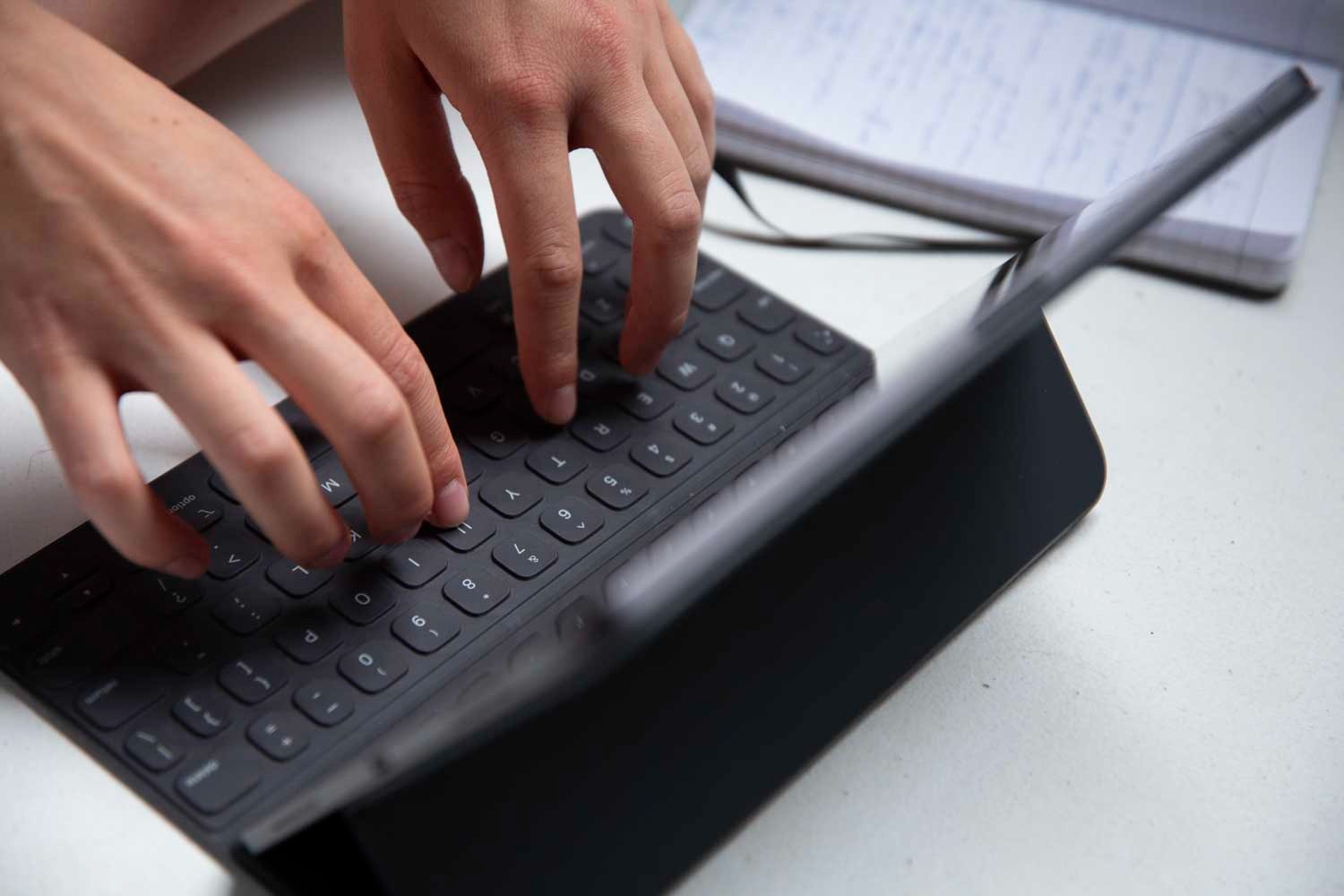 Mains tapant sur un clavier ajouté à une tablette