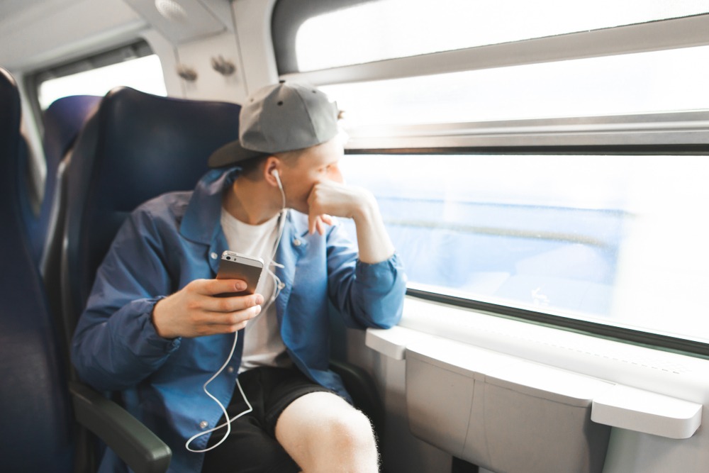 Photo d'Evan absorbé par un livre audio dans un autobus